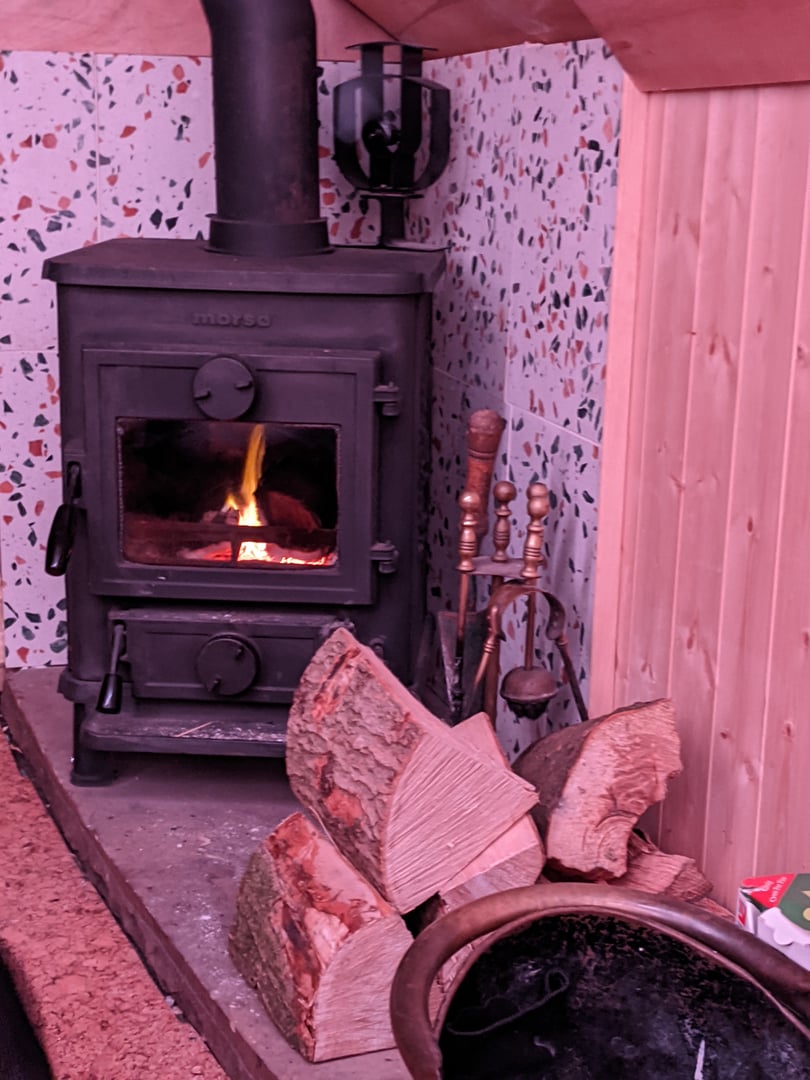 Cozy interior showing the wood stove and lighting